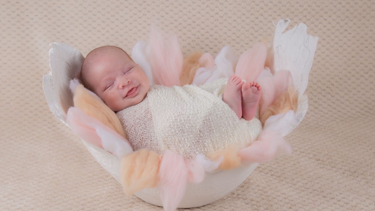 Улыбающийся спящий новорожденный малыш