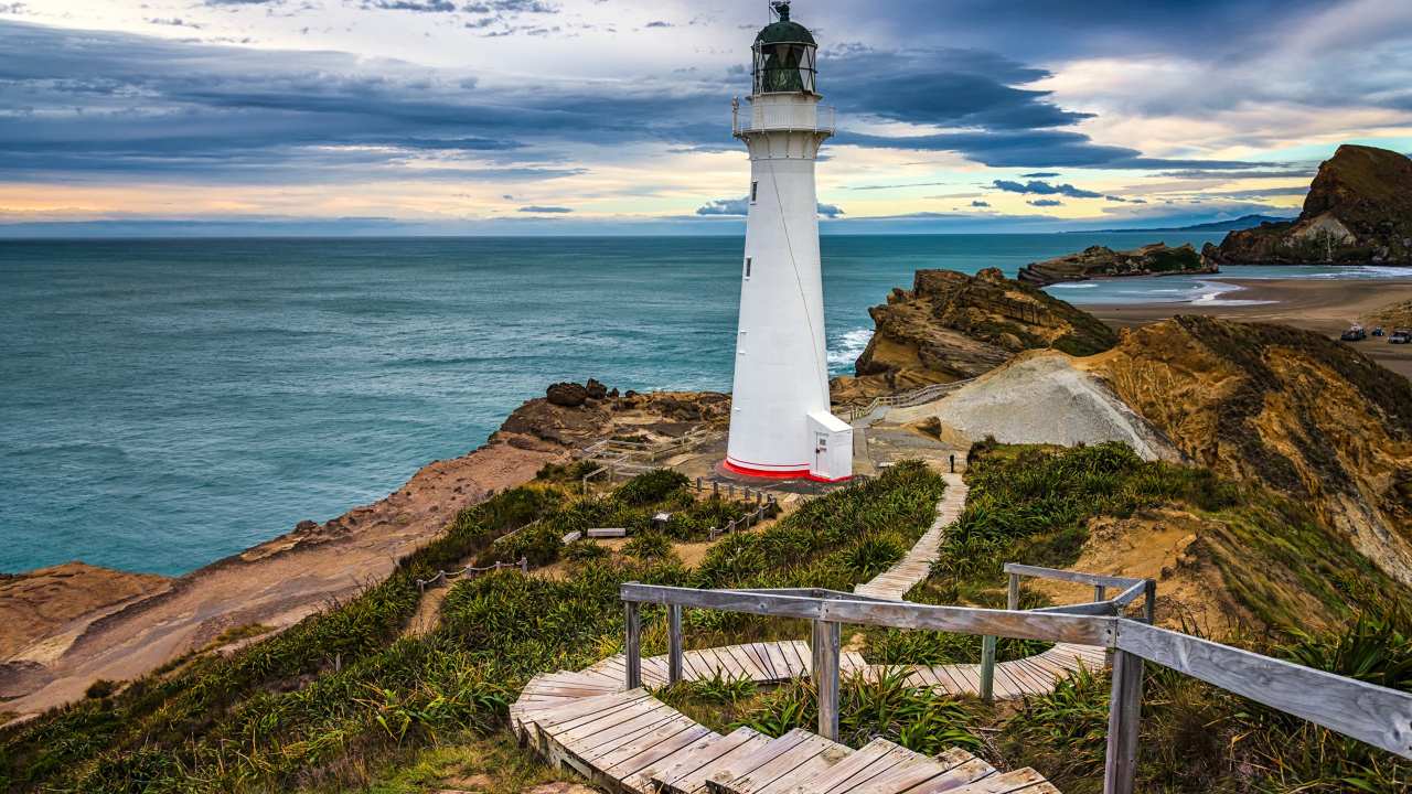 Маяк стоит на берегу моря на побережье Новой Зеландии