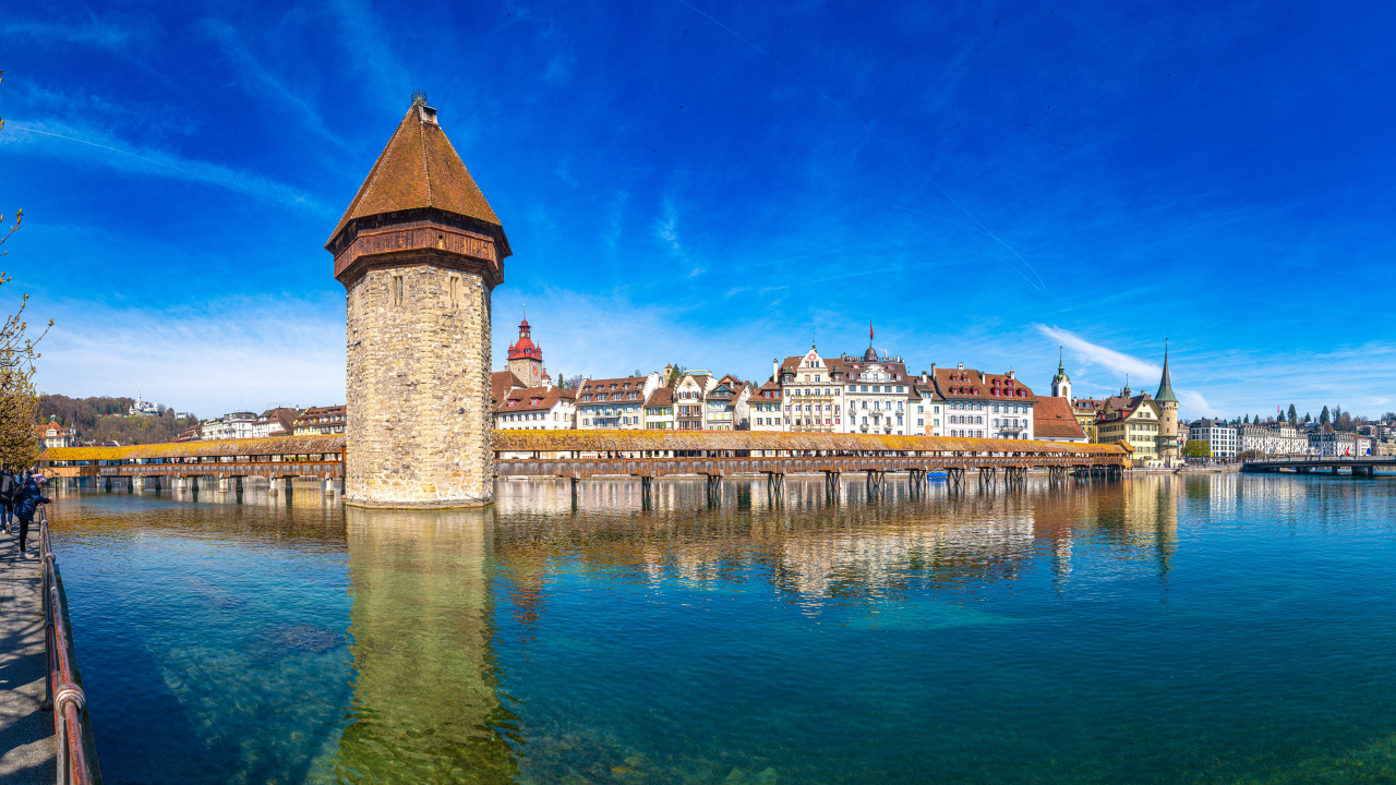 Башня и дома отражаются в воде, город Люцерн. Швейцария
