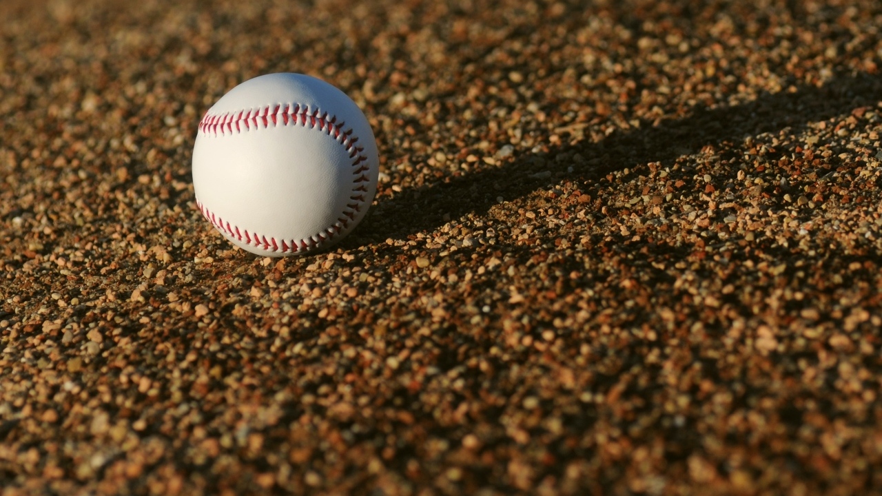 Бейсбольный мяч в лучах солнца на асфальте