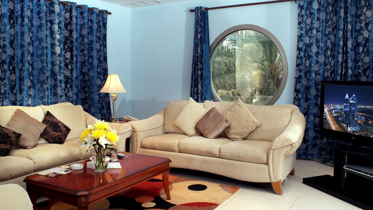 Синие шторы в гостиной с двумя диванами