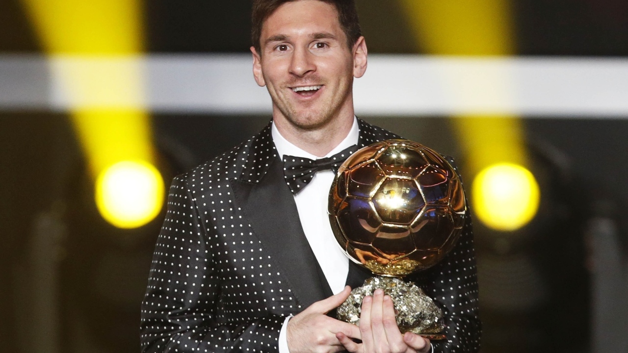 Футболист Лионель Месси с золотым мячом в руках