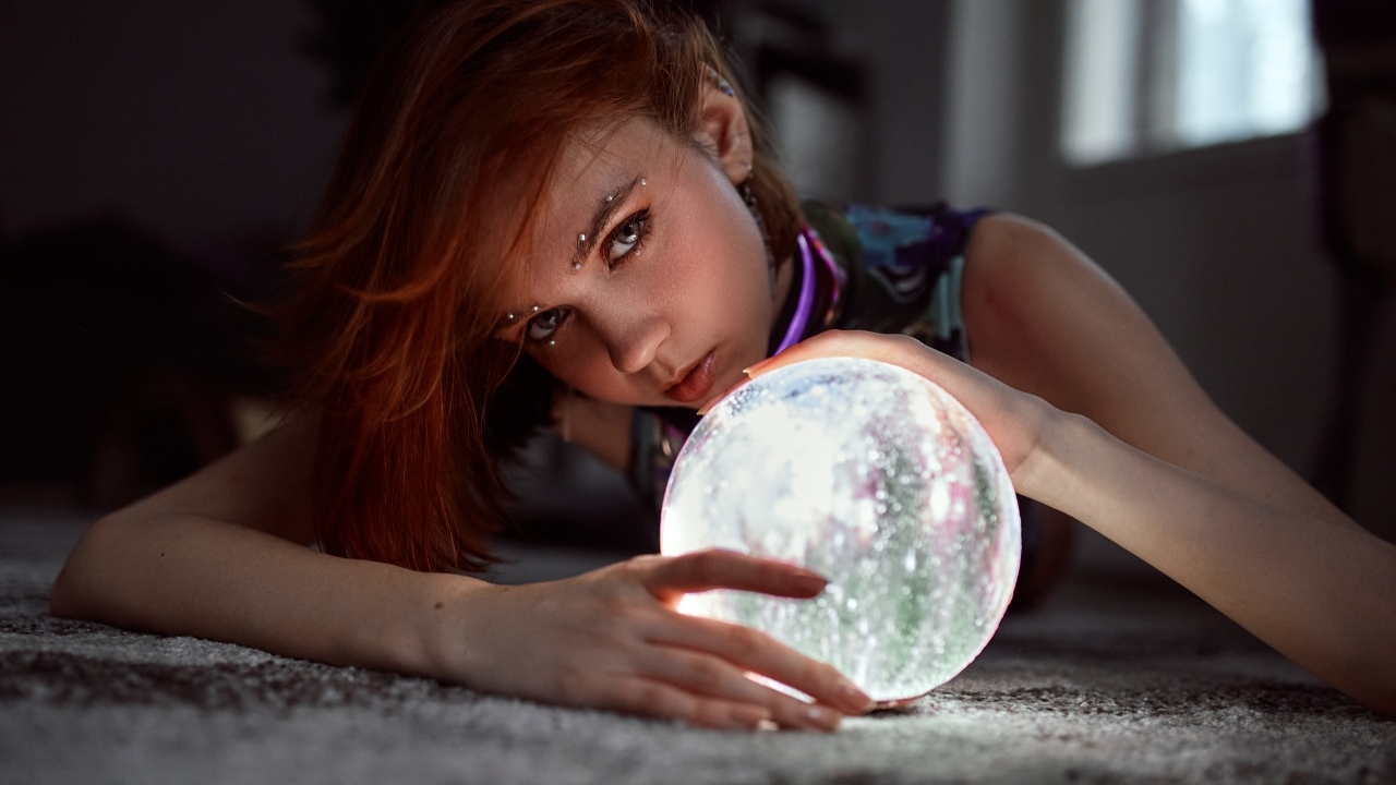 Девушка с пирсингом держит волшебный шар