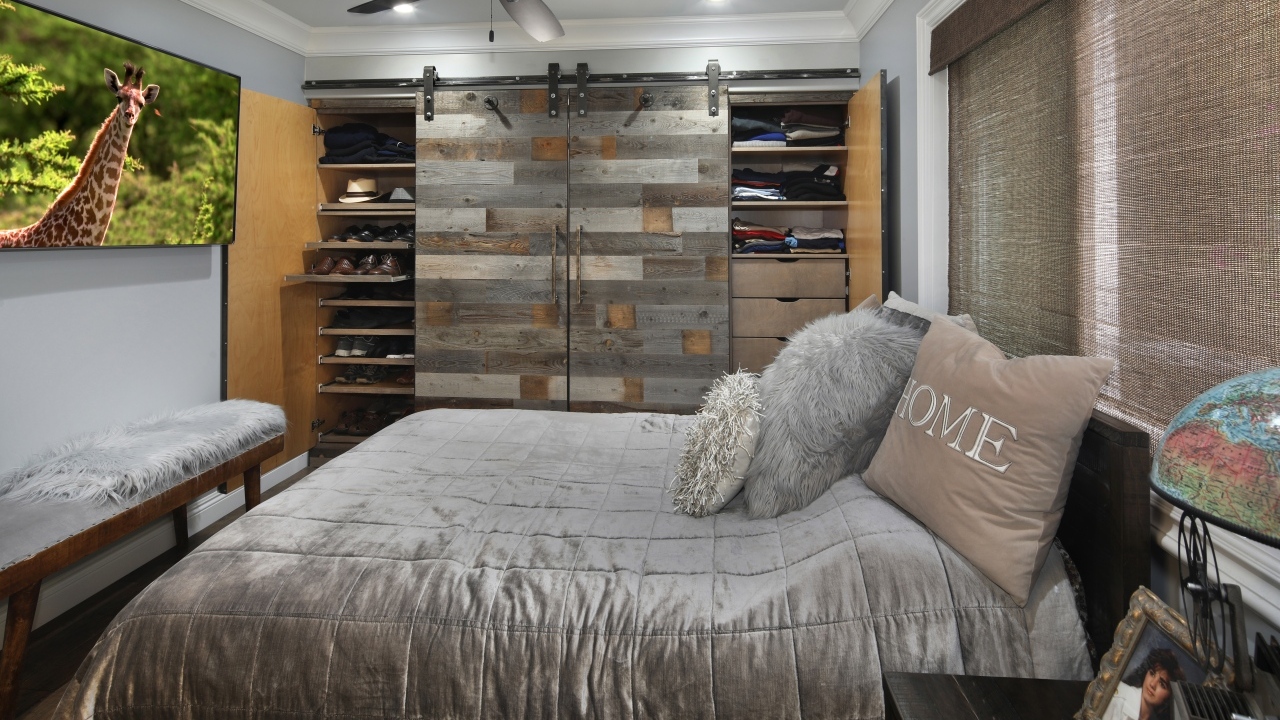Большая мягкая кровать в спальне с деревянным шкафом