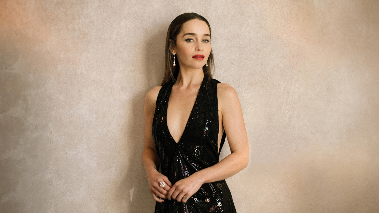 Популярная молодая актриса Эмилия Кларк в черном платье у стены