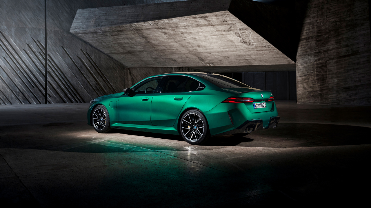 Вид сзади на зеленый автомобиль BMW M5 2024  года