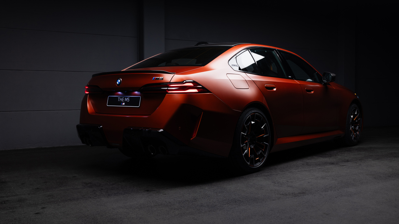 Вид сзади на красный автомобиль BMW M5 2025 года