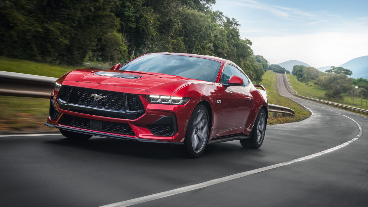 Красный автомобиль  Ford Mustang GT Performance 2024  года на дороге