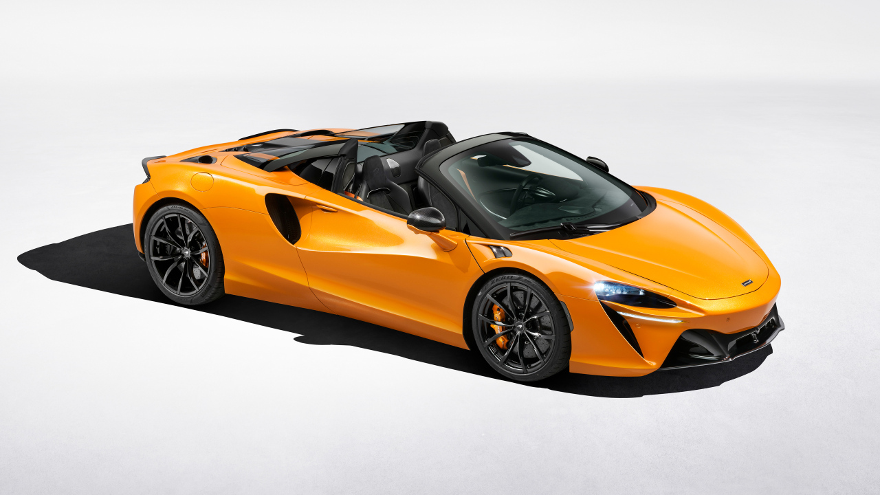 Оранжевый автомобиль McLaren Artura Spider на сером фоне