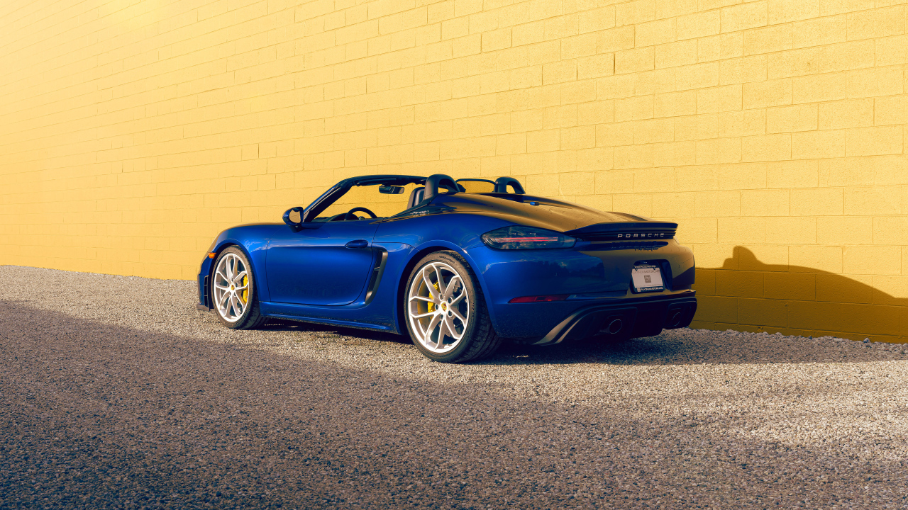 Вид сзади на синий автомобиль Porsche 718 Spyder