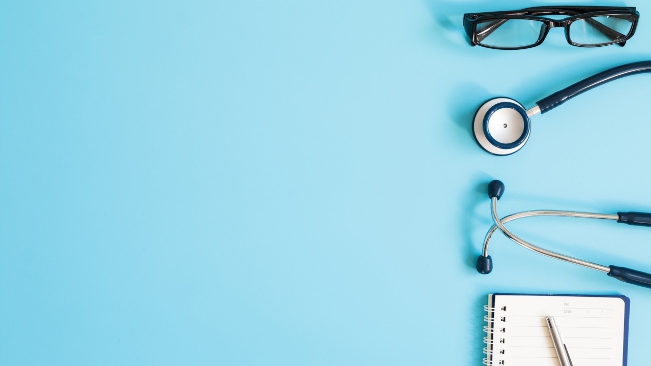 Стетоскоп, очки и блокнот на голубом фоне