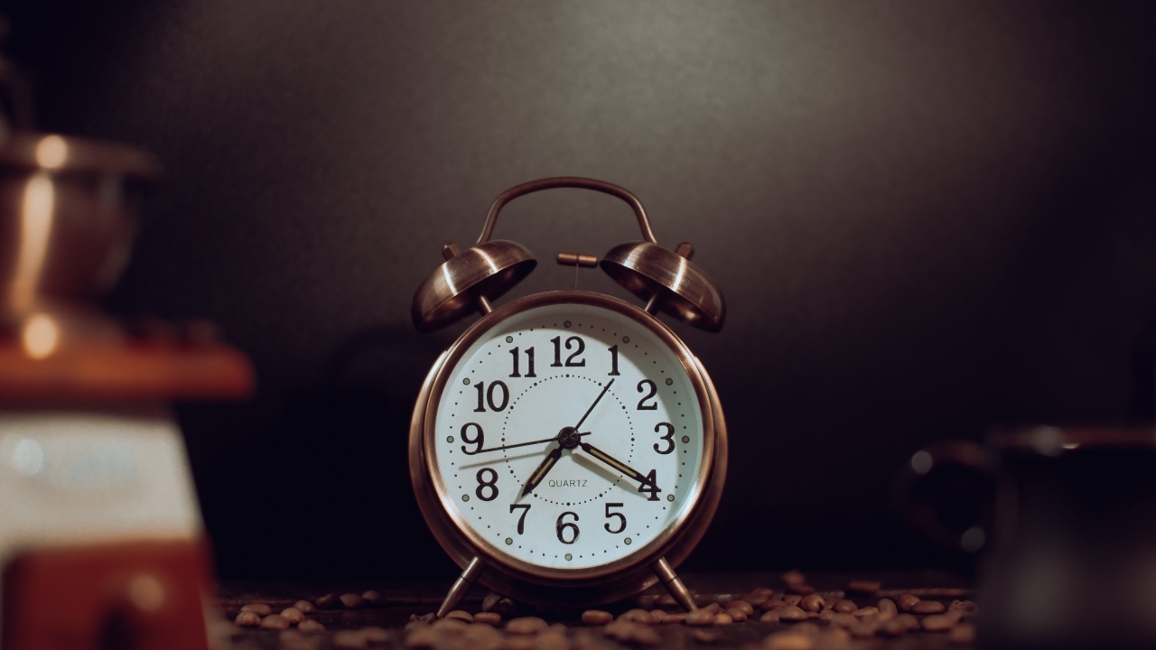 Будильник на столе с зернами кофе