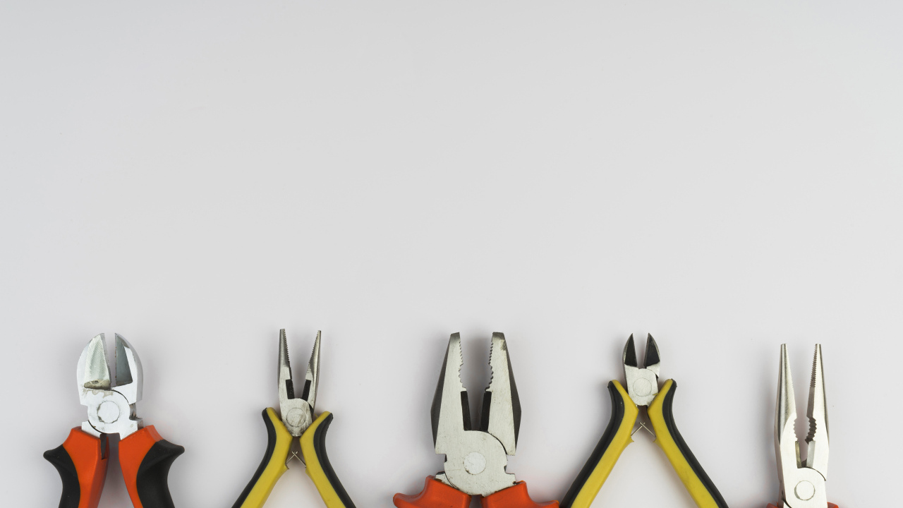 Разные плоскогубцы на сером фоне