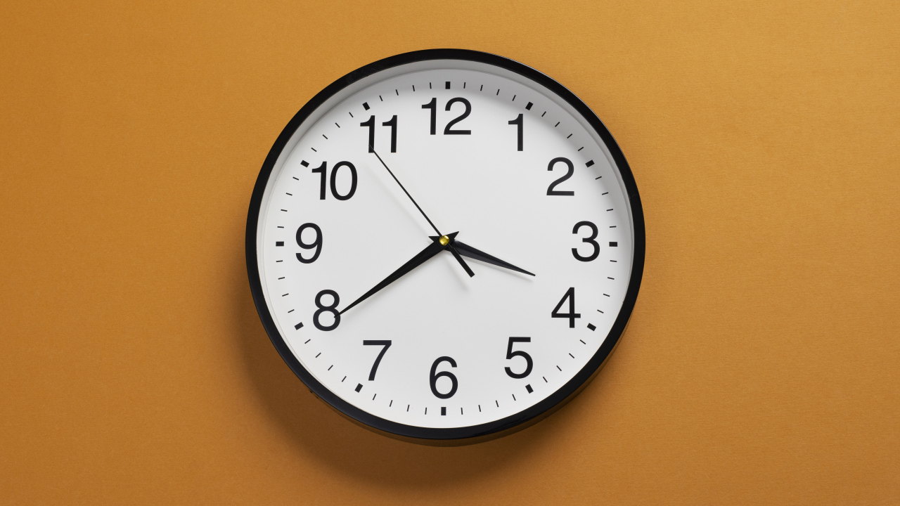 Большие круглые часы на желтом фоне