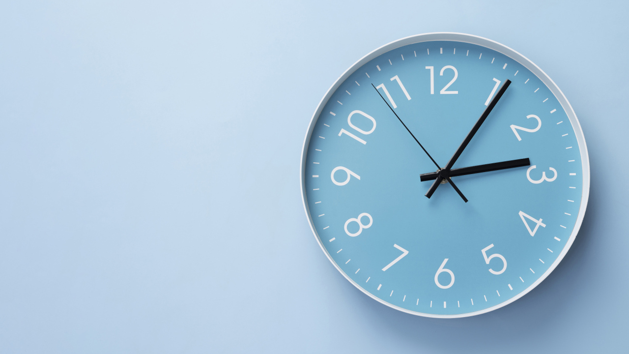 Круглые часы на голубом фоне крупным планом