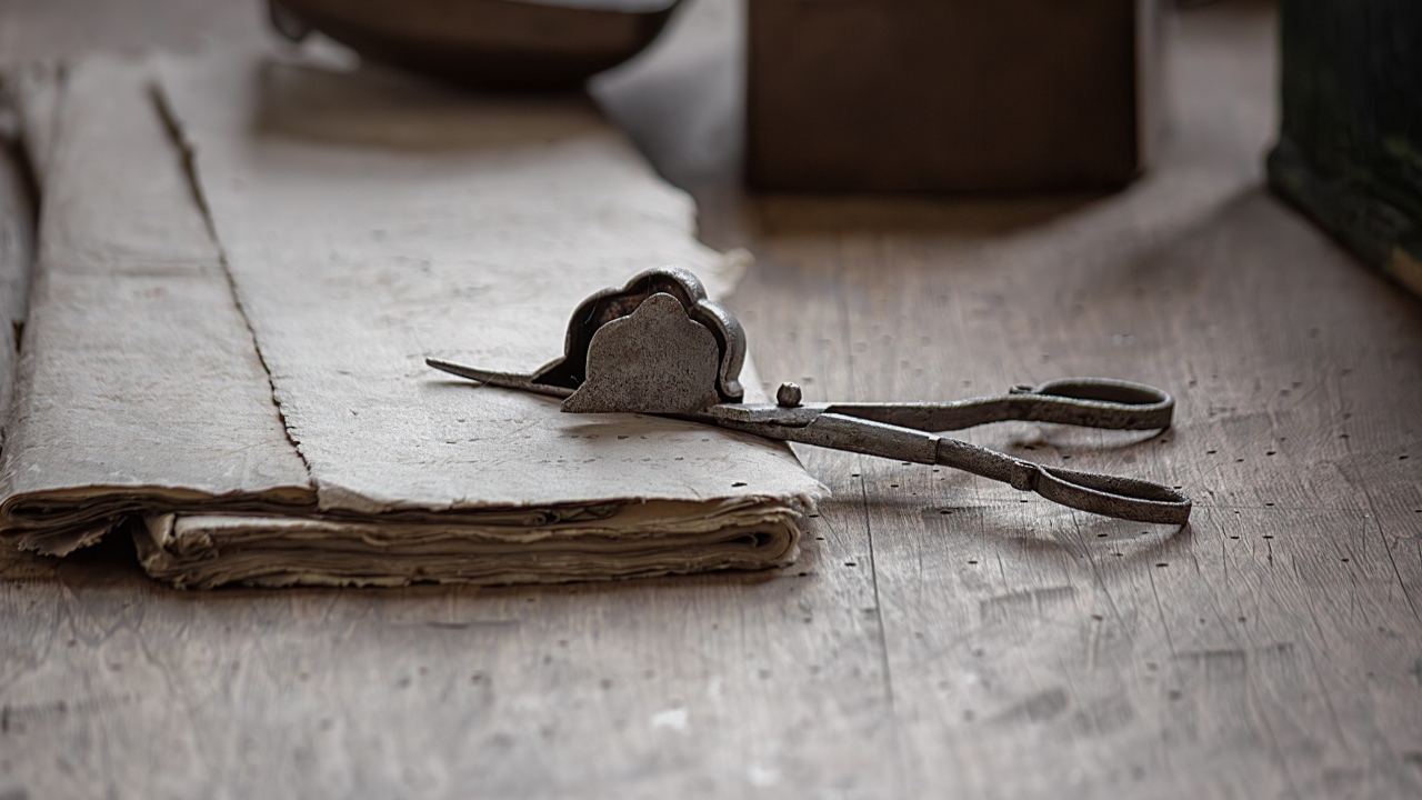 Старинные железные ножницы с бумагой на столе