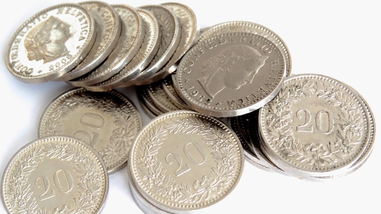 Много серебряных монет на сером фоне