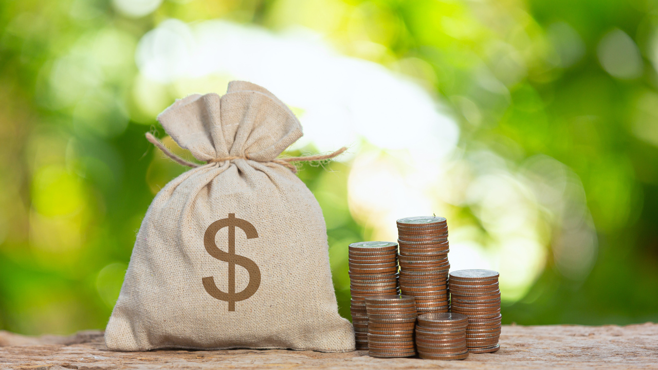 Мешок с деньгами на столе с монетами