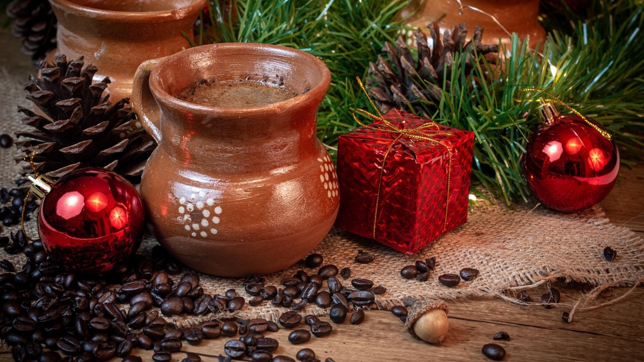 Кофейные зерна на столе с посудой и еловой веткой