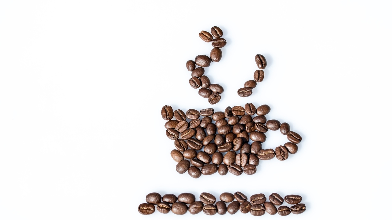 Чашка из кофейных зерен на белом столе