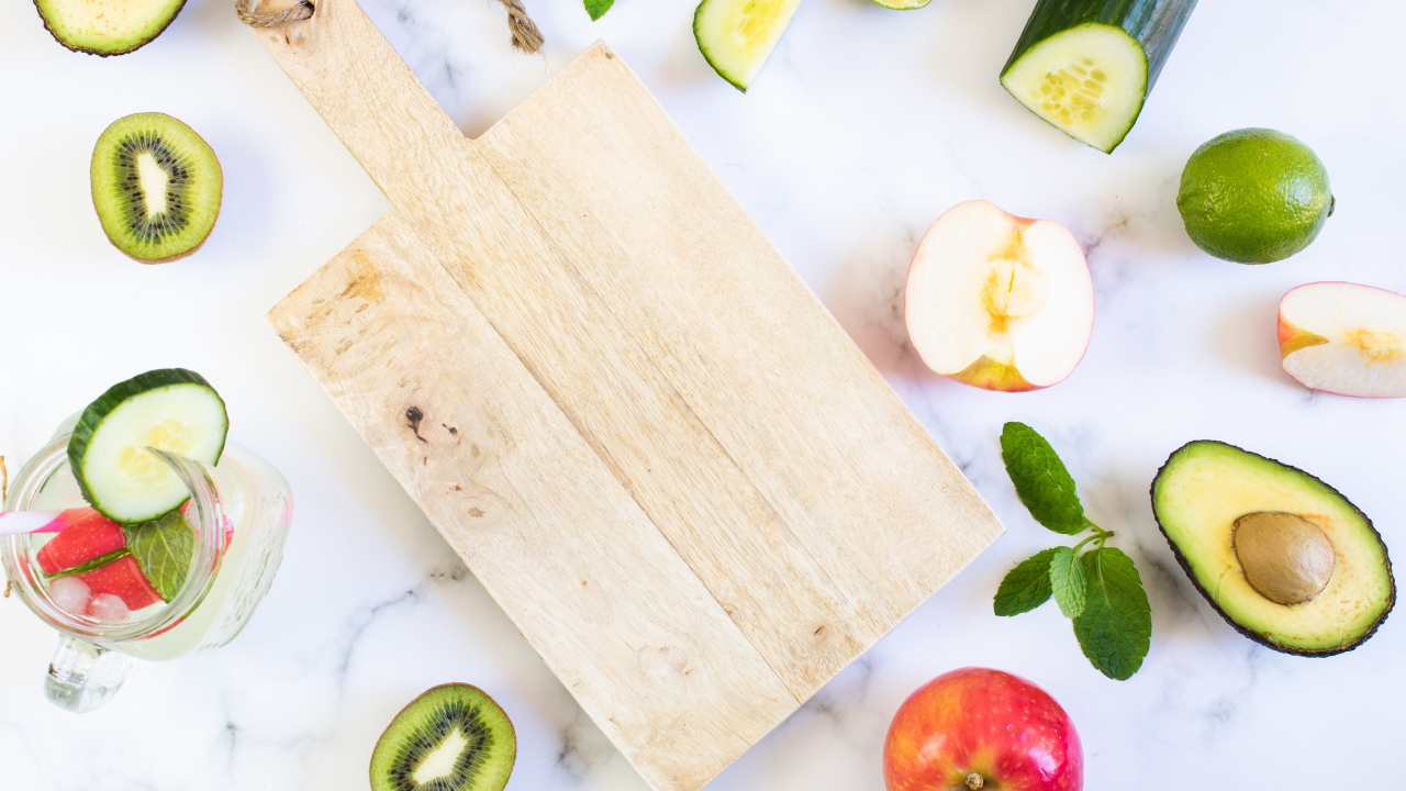 Разделочная доска с фруктами и овощами на столе