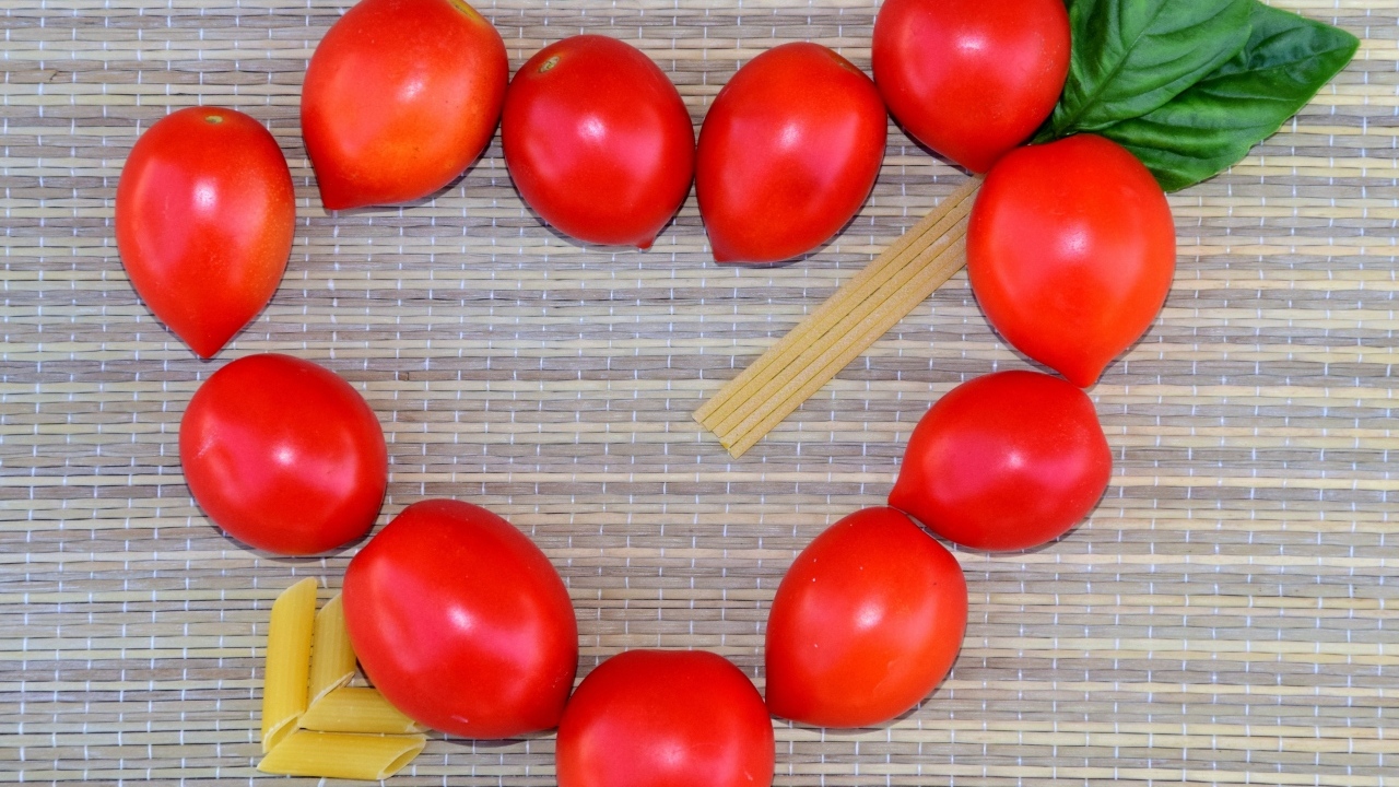 Сердце из помидоров на столе с макаронами
