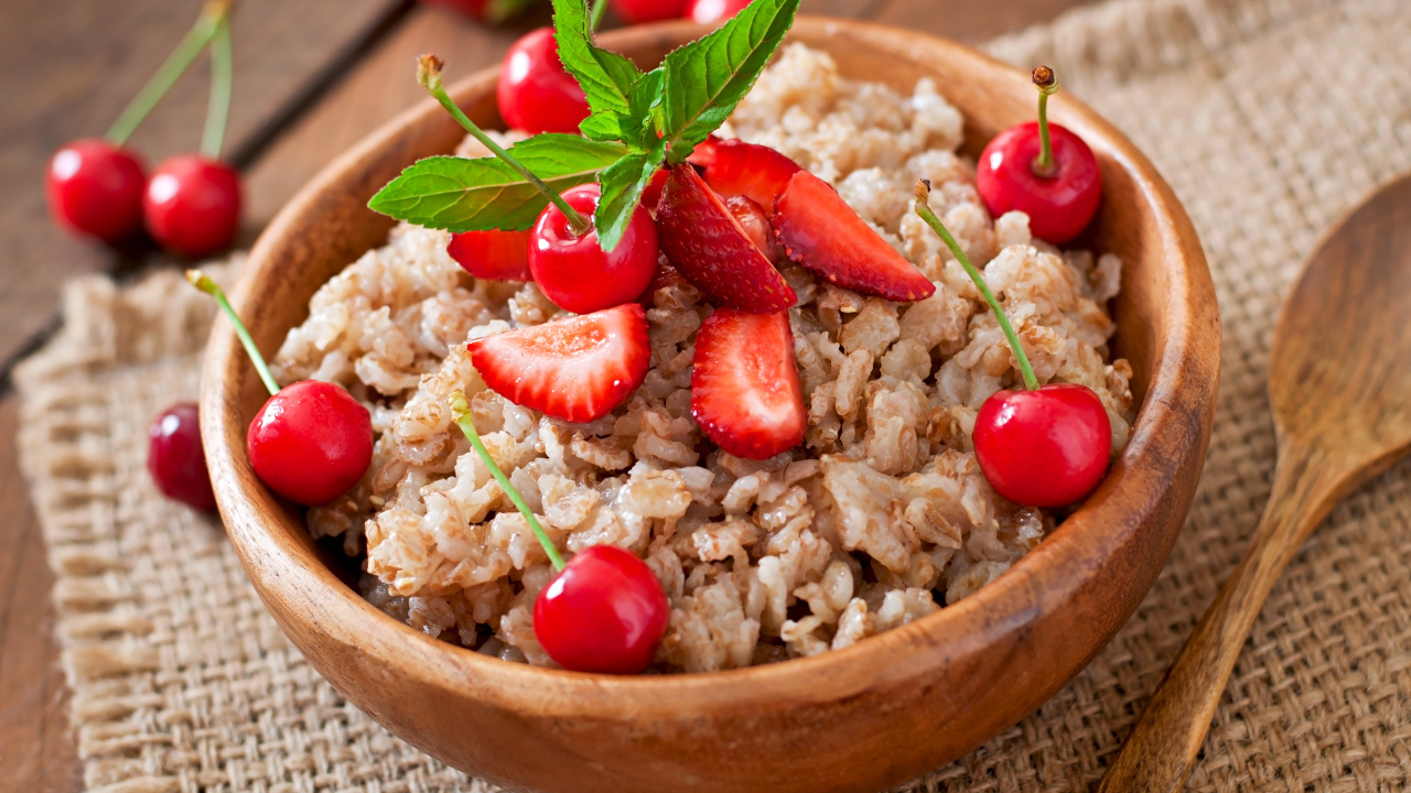 Овсяная каша с ягодами в деревянной миске