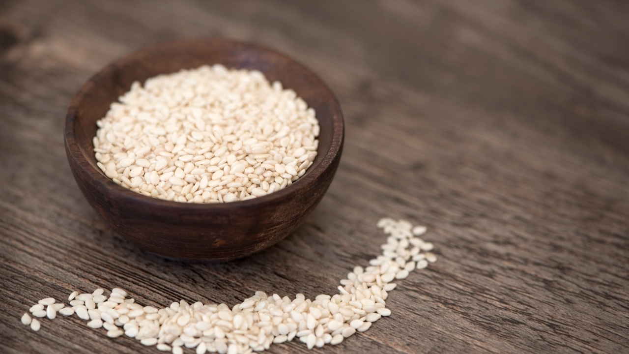 Зерна кунжута в деревянной миске на столе