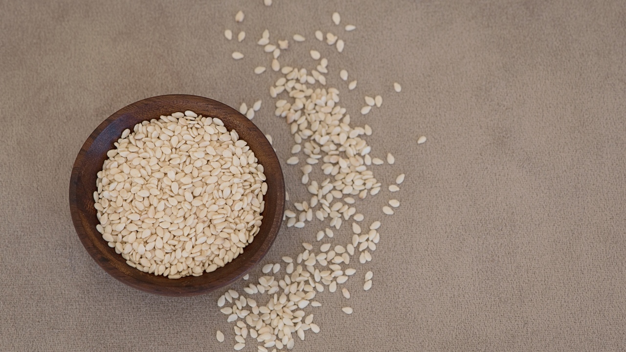 Зерна кунжута в деревянной миске на столе