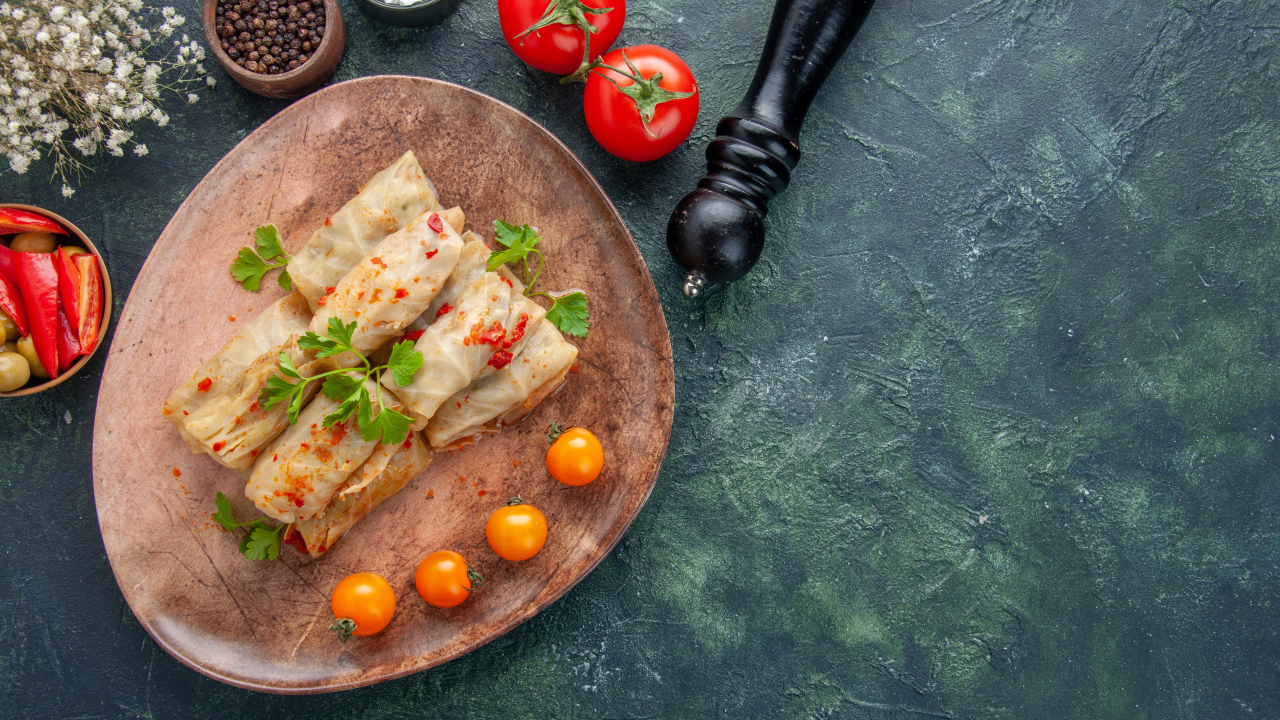 Голубцы на столе с помидорами и специями