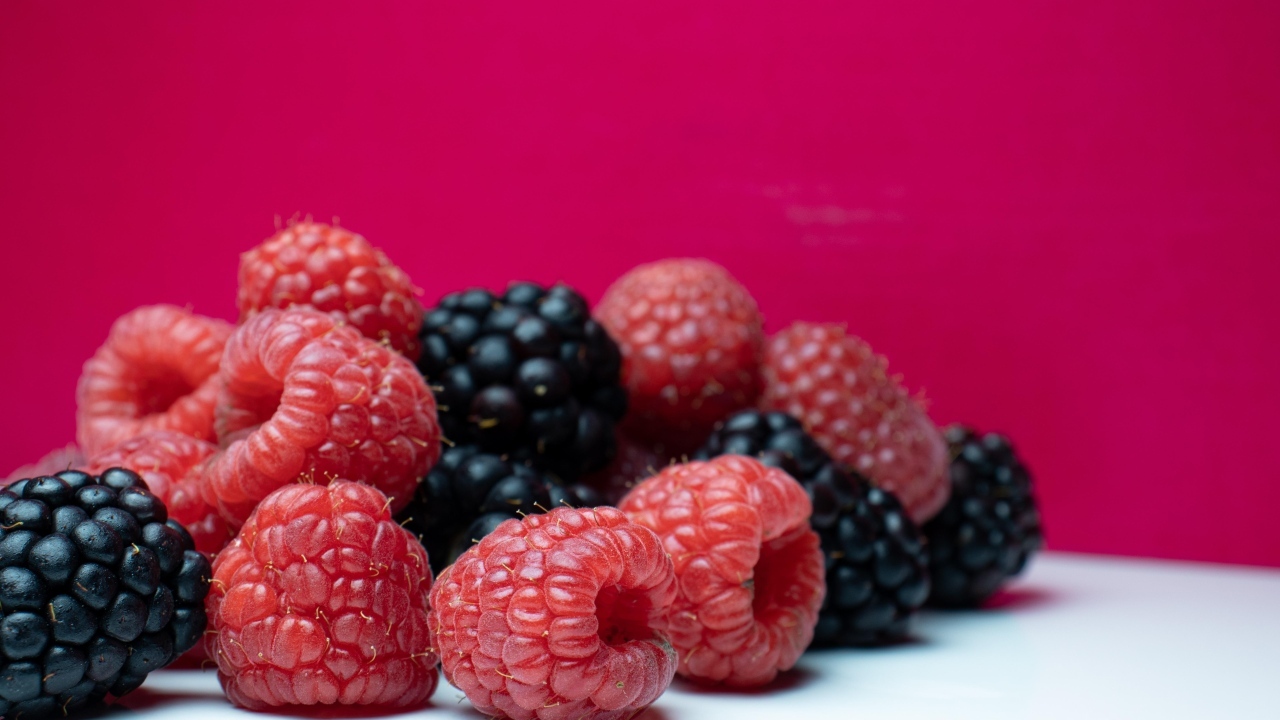 Ягоды черники и малины на красном фоне