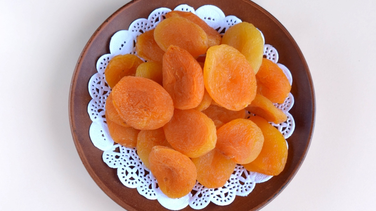 Курага с тарелке на сером фоне