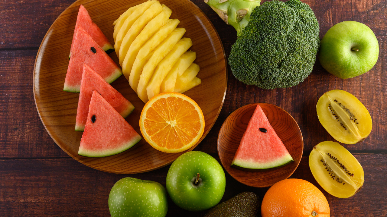 Фрукты и брокколи на столе с доской