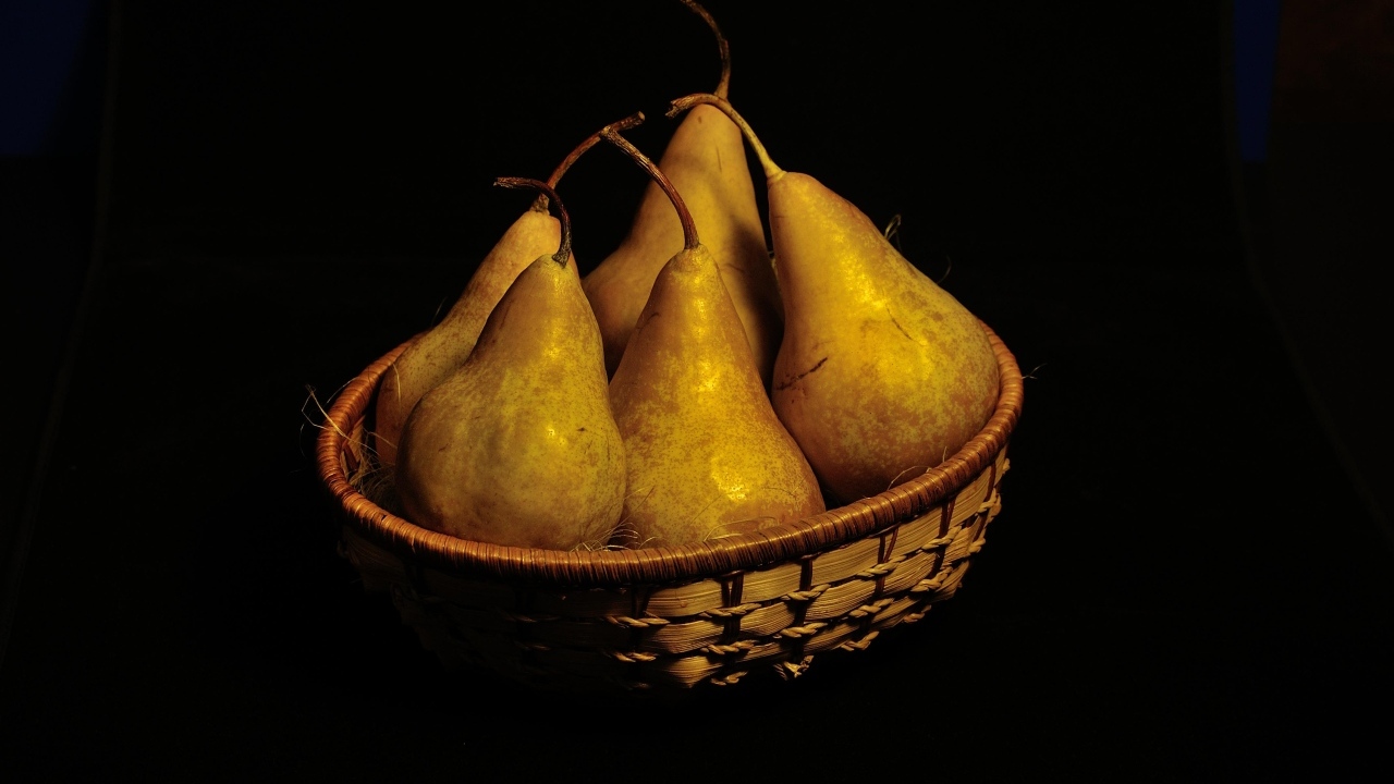 Груши в корзинке на черном фоне