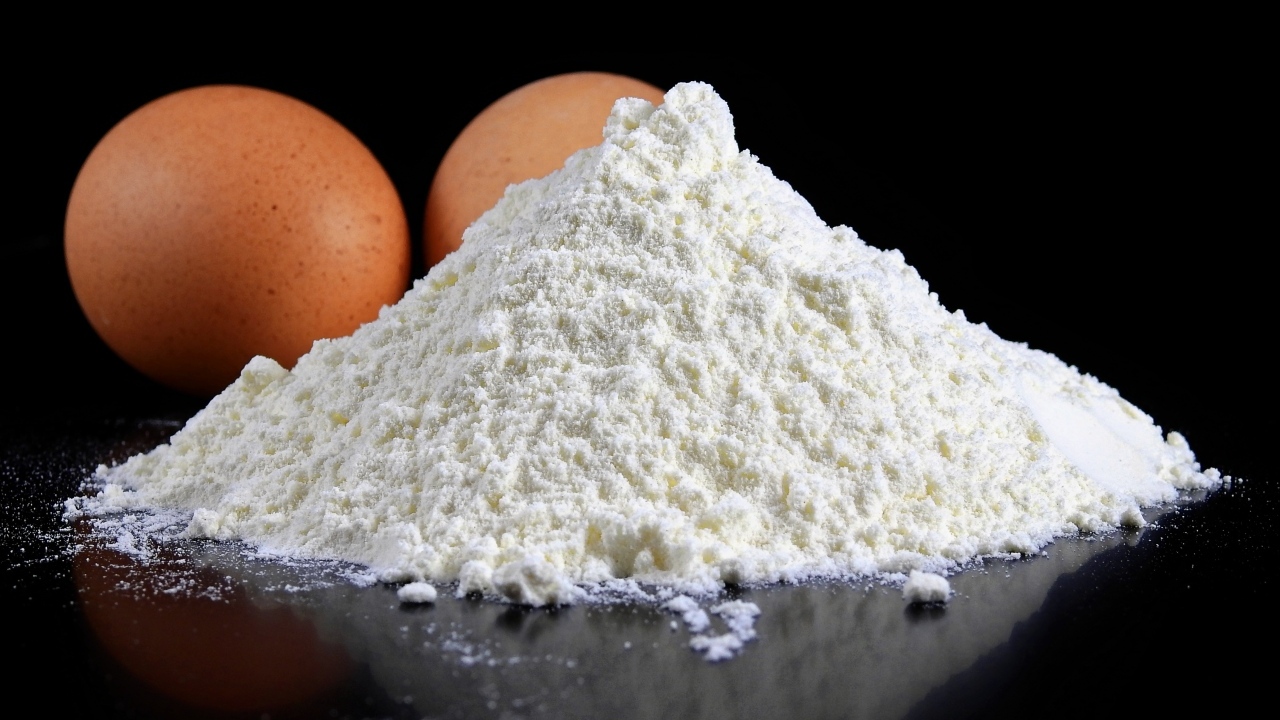 Мука на черном столе с куриными яйцами