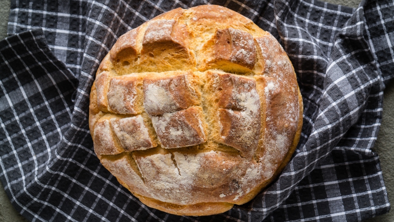 Круглый хрустящий хлеб на столе со скатертью