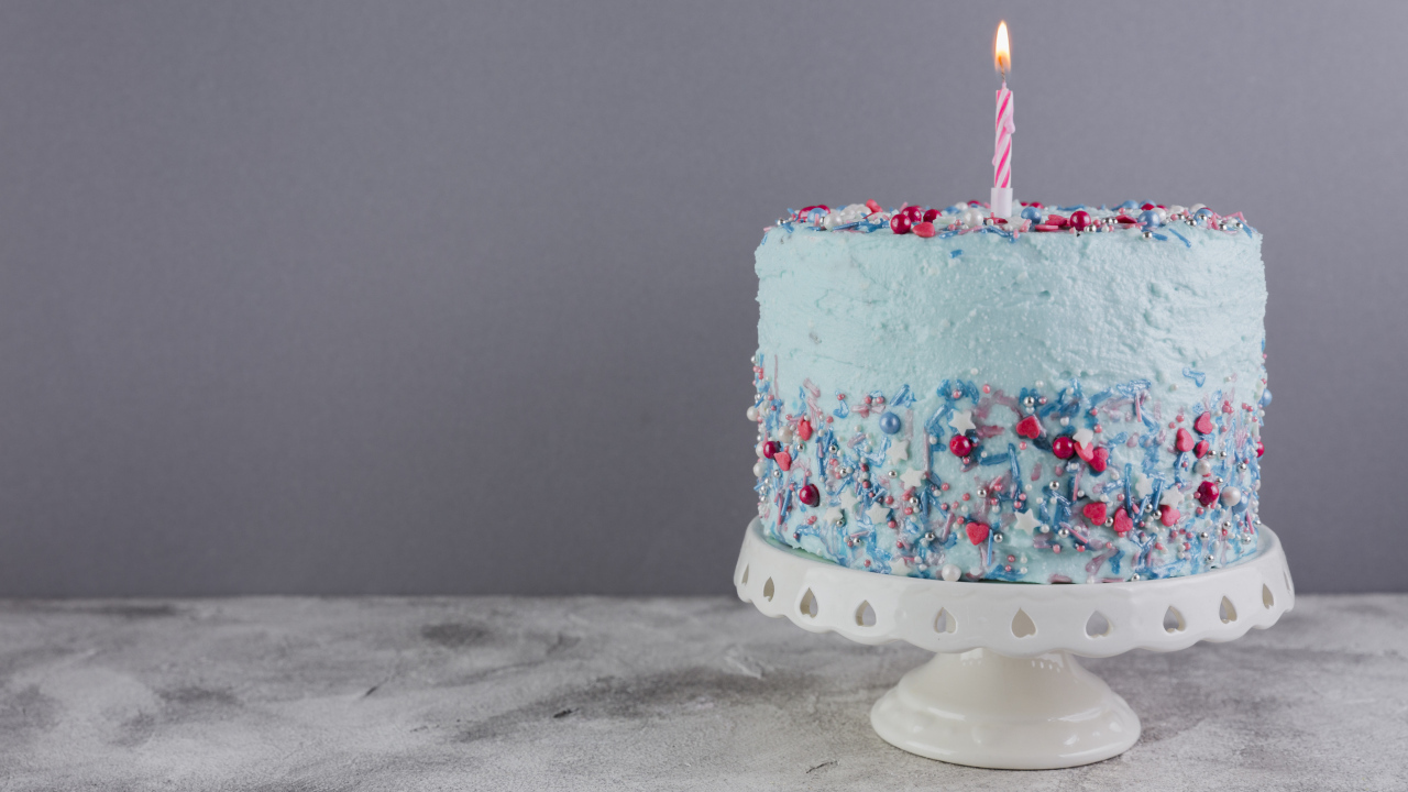 Праздничный торт в голубой глазури с одной свечкой