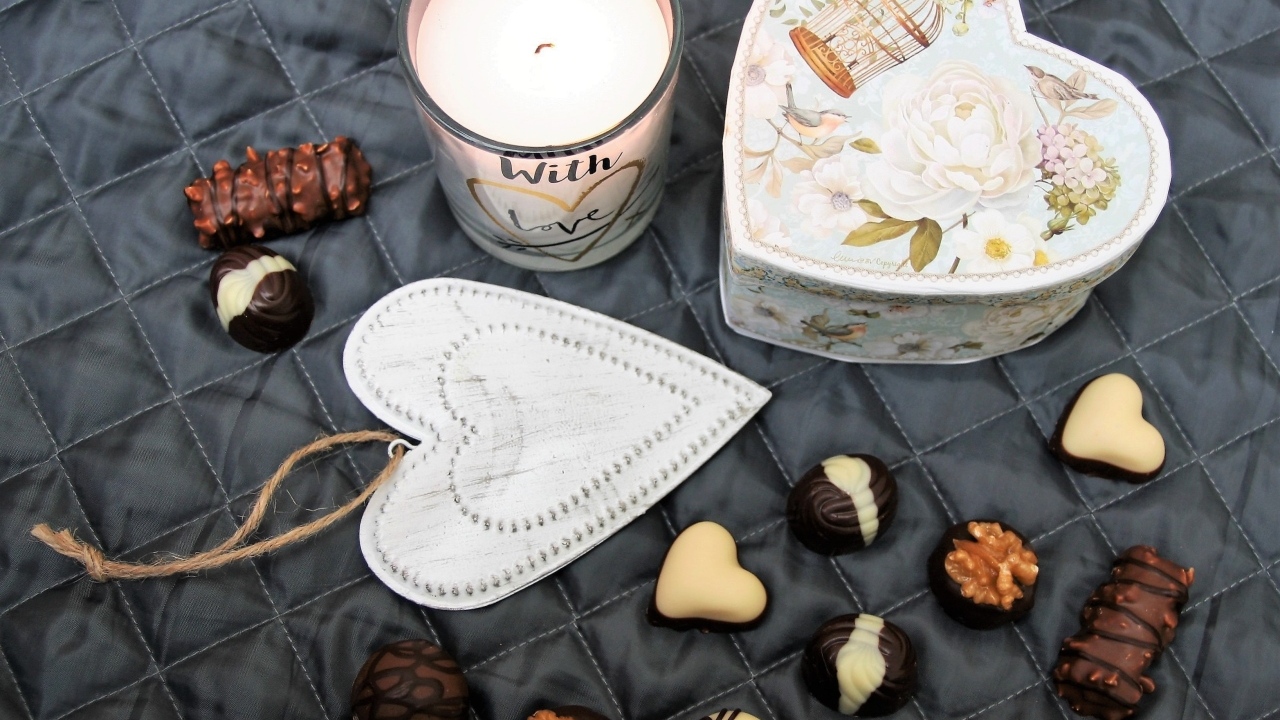 Коробка на кровати с конфетами и свечой