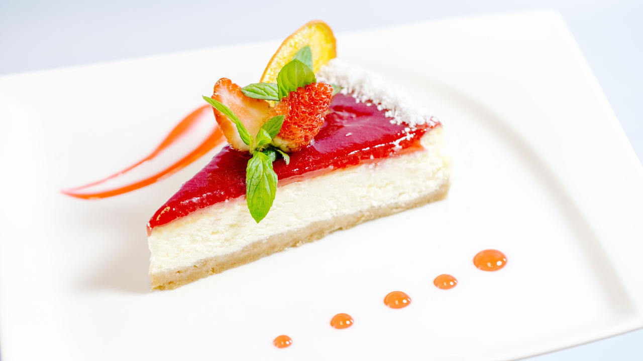 Чизкейк с клубничным джемом и ягодами на белой тарелке