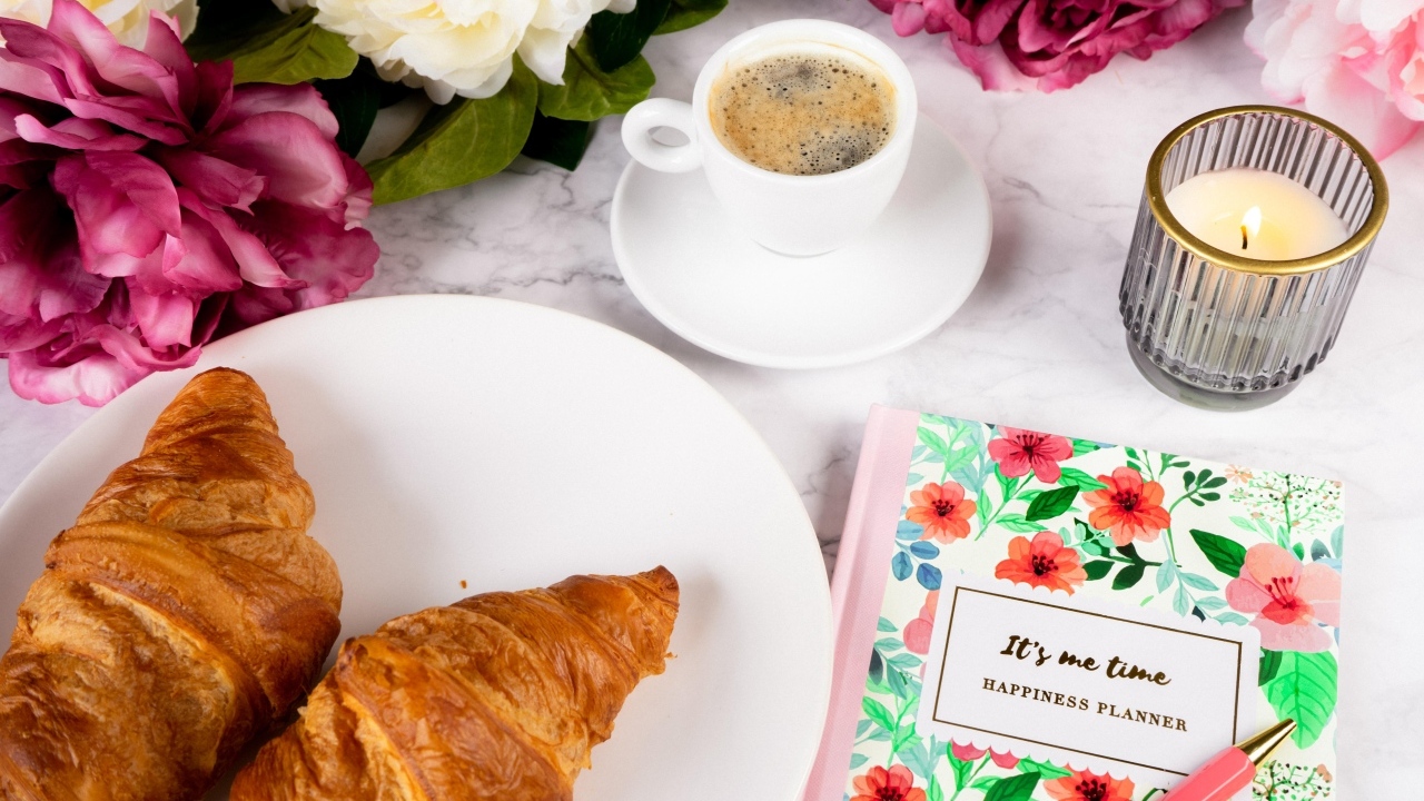 Круассаны на столе с кофе и цветами