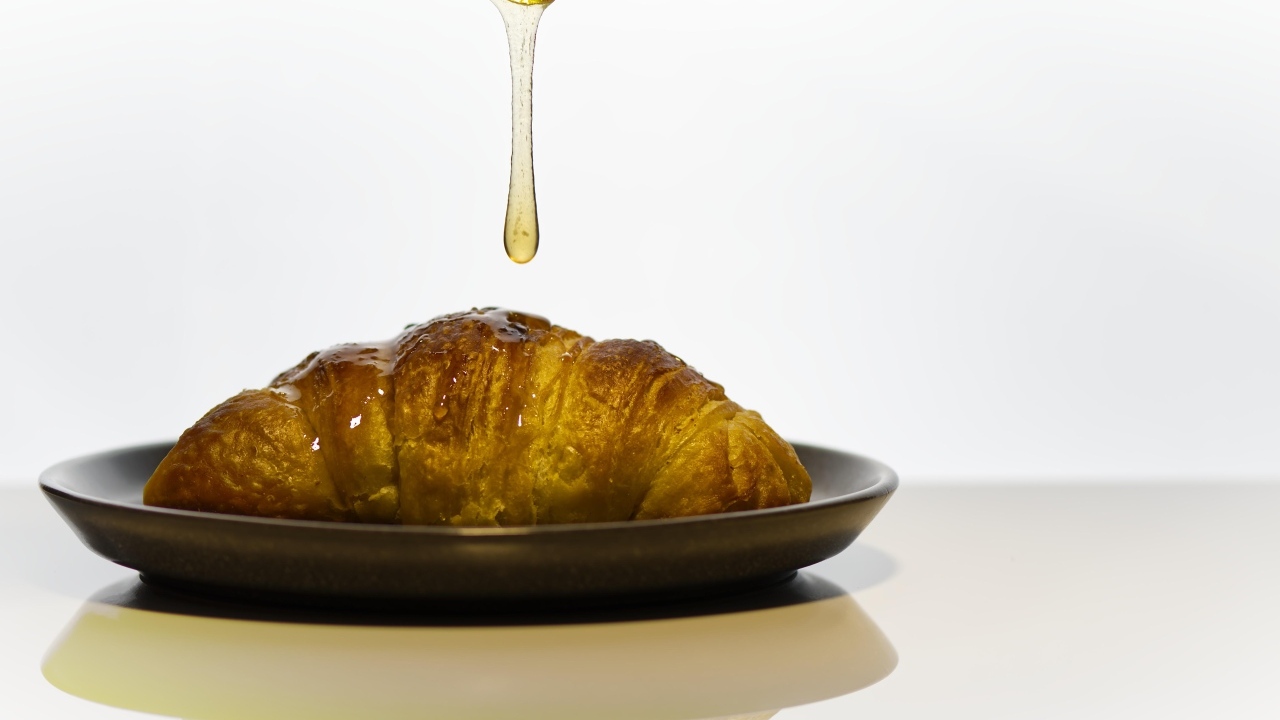 Свежий круассан с медом на завтрак