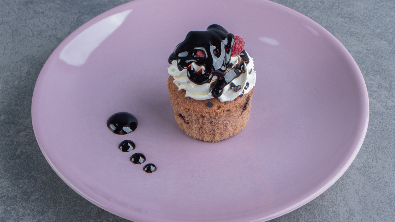 Маффин с шоколадным топпингом на большой тарелке