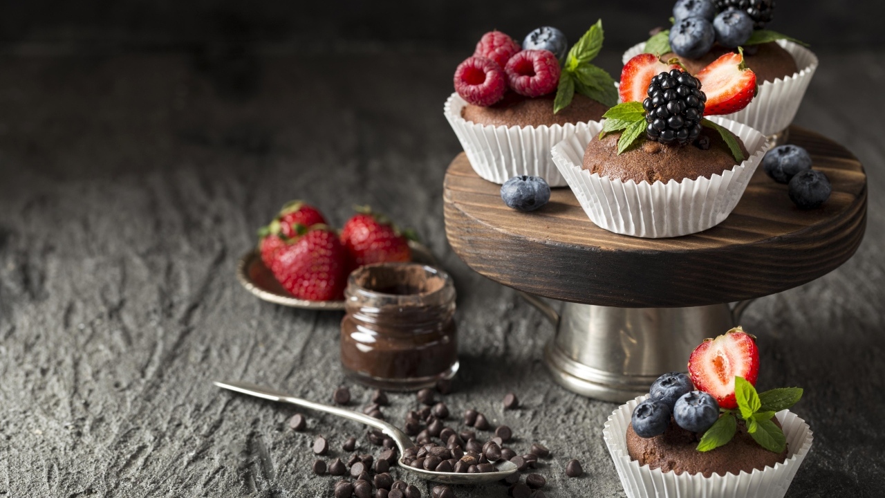 Кексы со свежими ягодами на столе с шоколадом