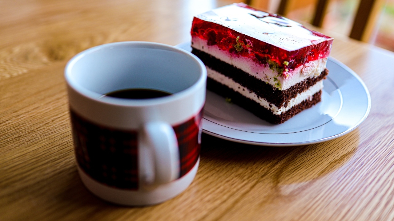 Кусок торта с чашкой кофе на деревянном столе