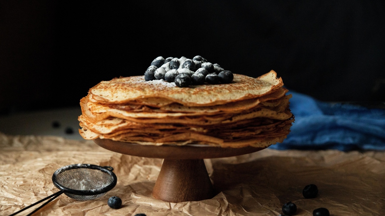 Тонкие сладкие блинчики с ягодами черники и сахарной пудрой