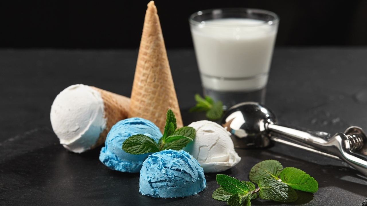 Вафельный рожок с шариками мороженого, мятой и молоком на столе