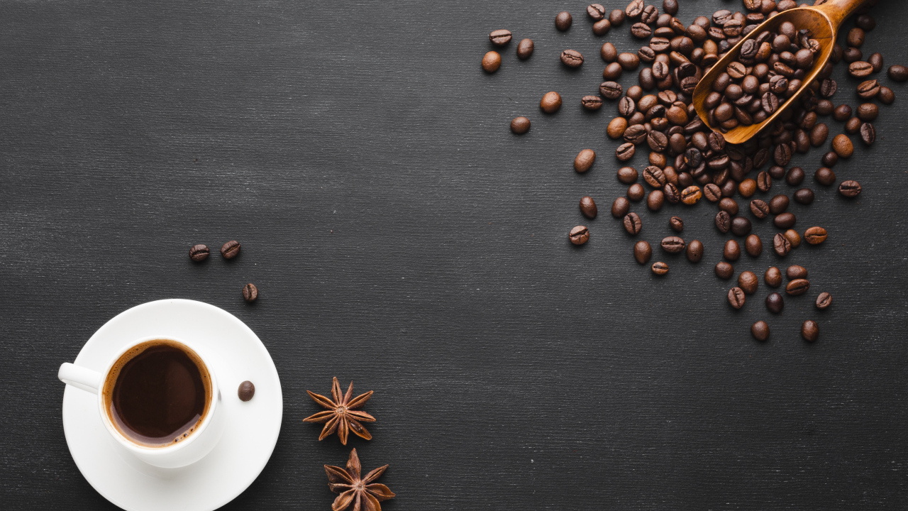 Чашка кофе на черном столе с зернами