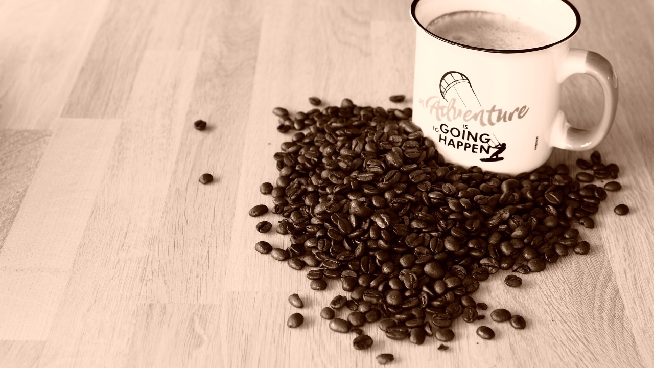 Чашка кофе на деревянном столе с кофейными зернами