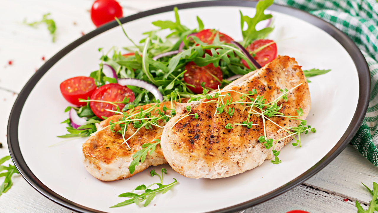 Жареная курица на тарелке с салатом