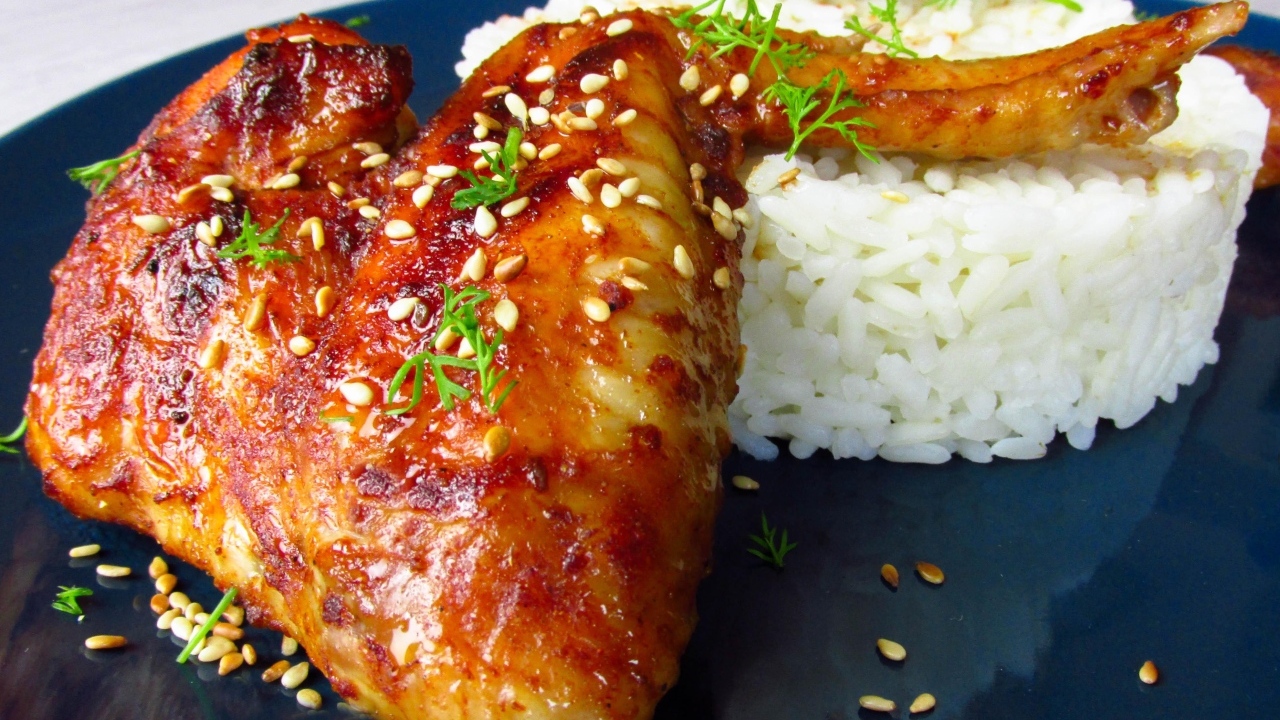 Рис на тарелке с жареным куриным крылом